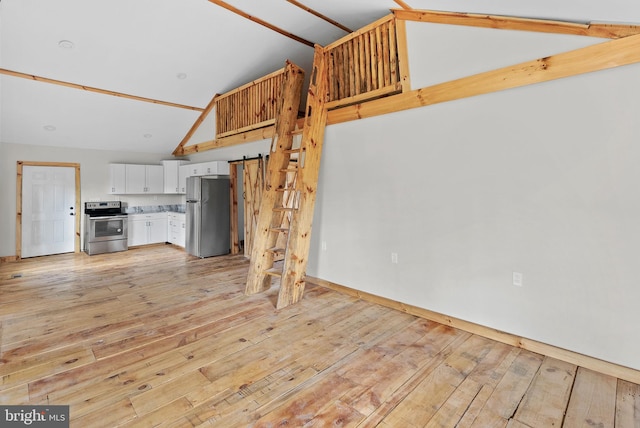 unfurnished living room featuring high vaulted ceiling and light hardwood / wood-style floors