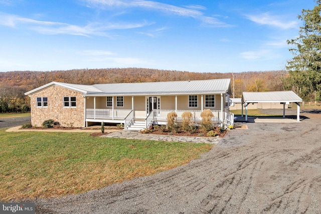 ranch-style house featuring a porch, a carport, and a front lawn