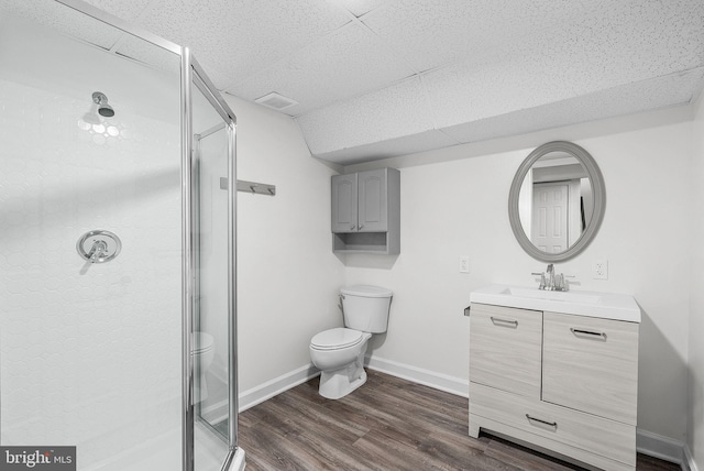 bathroom with toilet, vanity, an enclosed shower, and hardwood / wood-style flooring