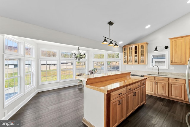 kitchen with vaulted ceiling, a wealth of natural light, a kitchen island, and sink