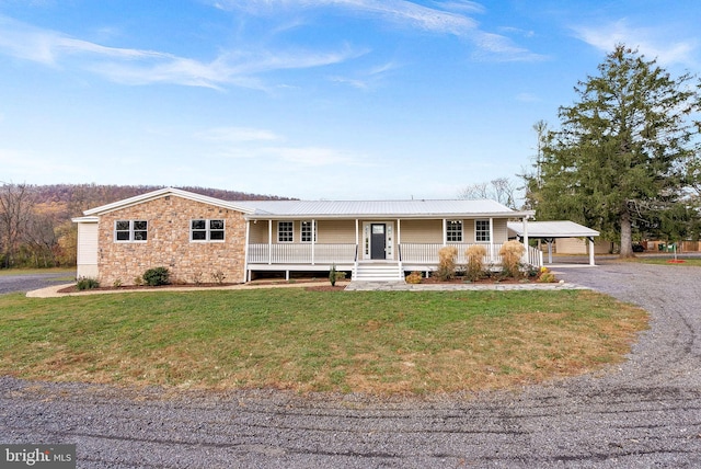 ranch-style home with a carport, covered porch, and a front yard