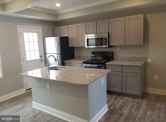 kitchen featuring appliances with stainless steel finishes, sink, light stone counters, and gray cabinetry