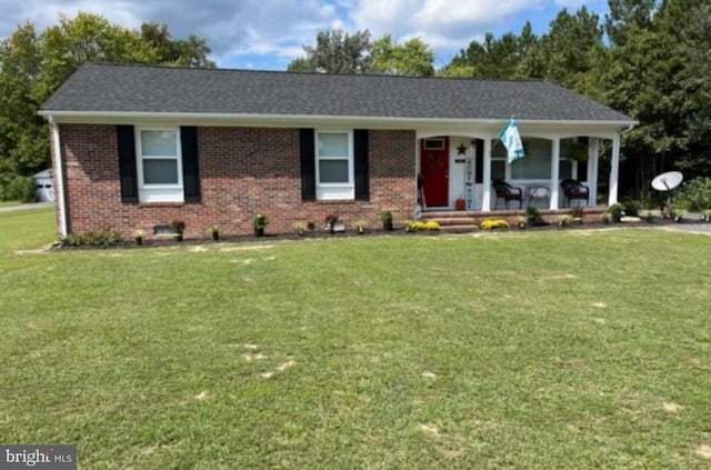 ranch-style house featuring covered porch and a front lawn