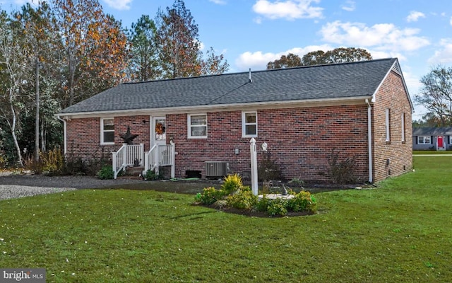 rear view of property featuring a yard and central AC