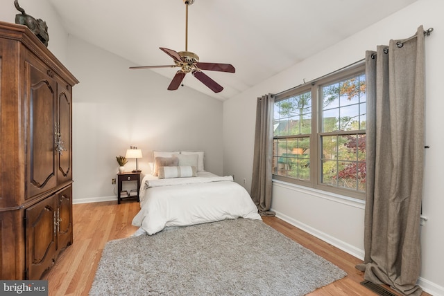 bedroom featuring ceiling fan, light hardwood / wood-style floors, and vaulted ceiling