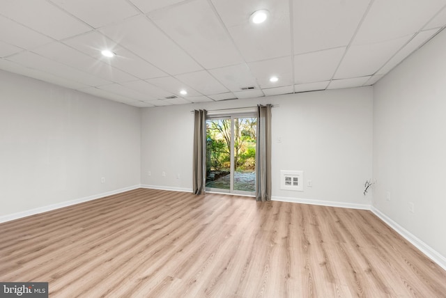 empty room featuring light wood-type flooring and a paneled ceiling