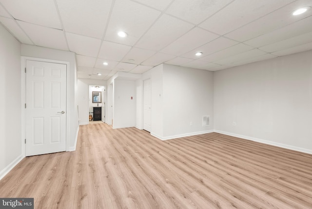 interior space featuring a drop ceiling and light wood-type flooring