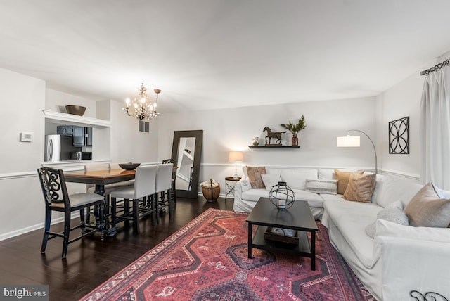 living room with dark wood-type flooring and a chandelier