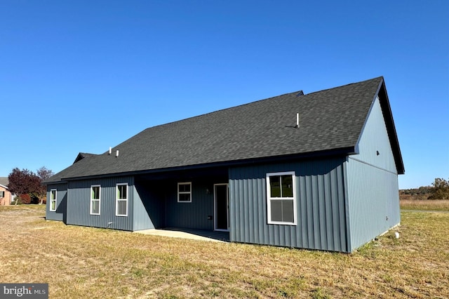 rear view of house with a patio and a yard