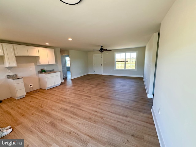 unfurnished living room featuring light wood-type flooring and ceiling fan