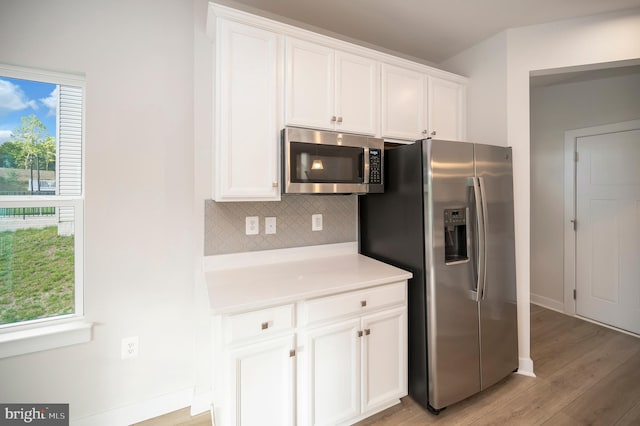 kitchen with white cabinets, a wealth of natural light, and stainless steel appliances