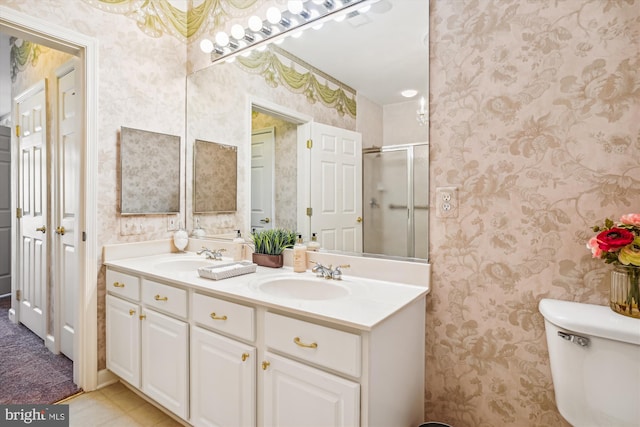 bathroom featuring vanity, toilet, and a shower with door