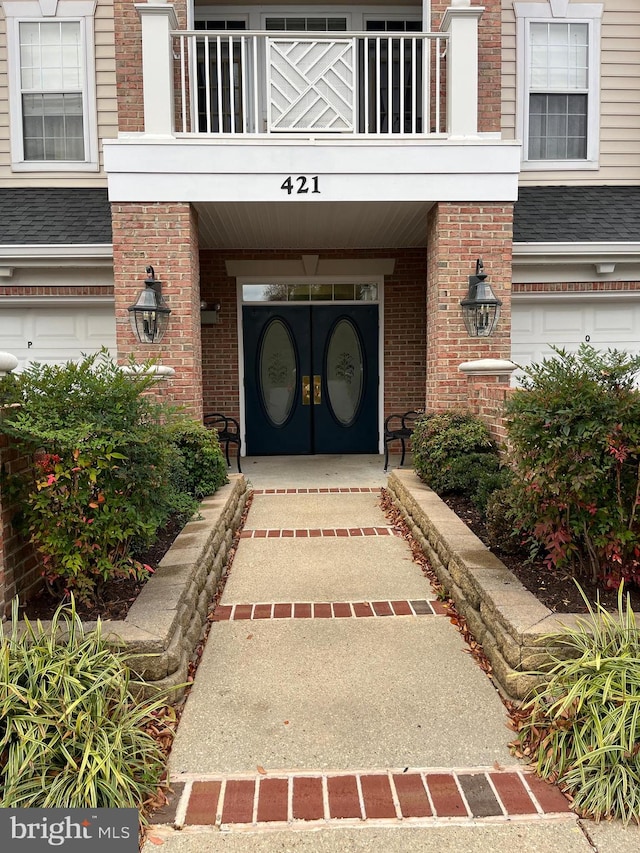 view of exterior entry with a balcony