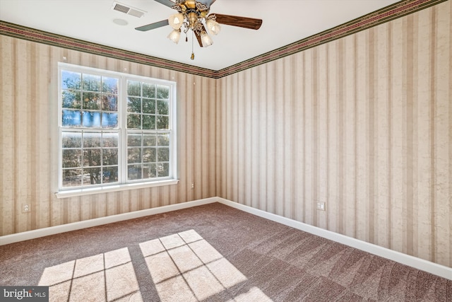 carpeted spare room with ceiling fan and ornamental molding