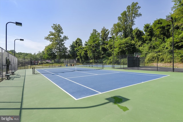 view of tennis court with basketball hoop