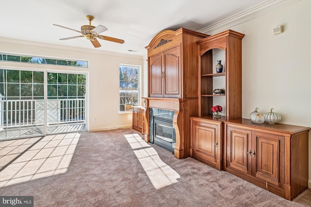 unfurnished living room featuring light colored carpet, ceiling fan, and ornamental molding