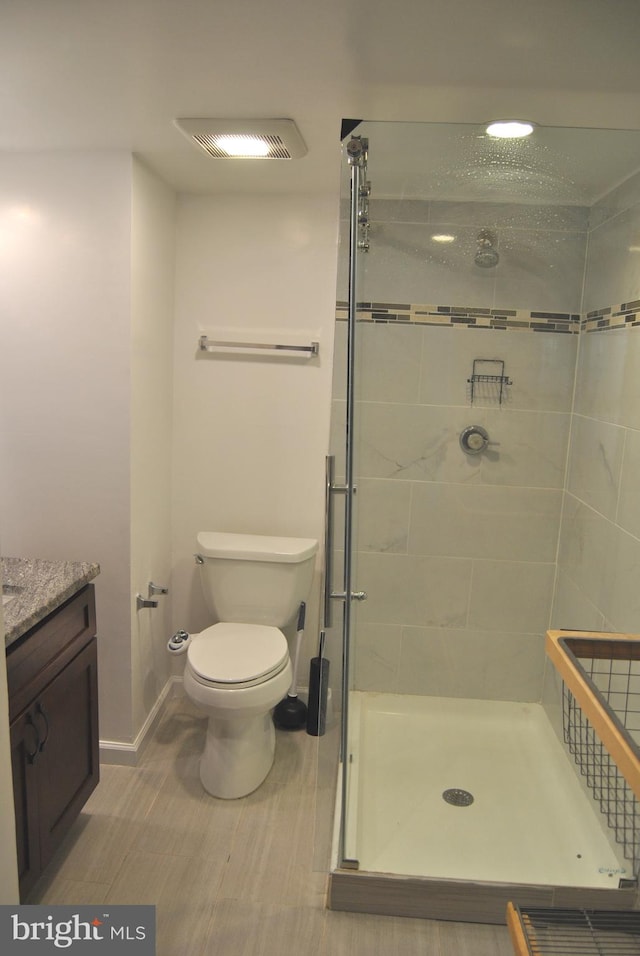 bathroom featuring toilet, vanity, and walk in shower