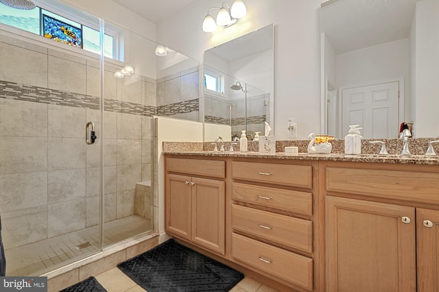 bathroom with walk in shower, vanity, and tile patterned floors