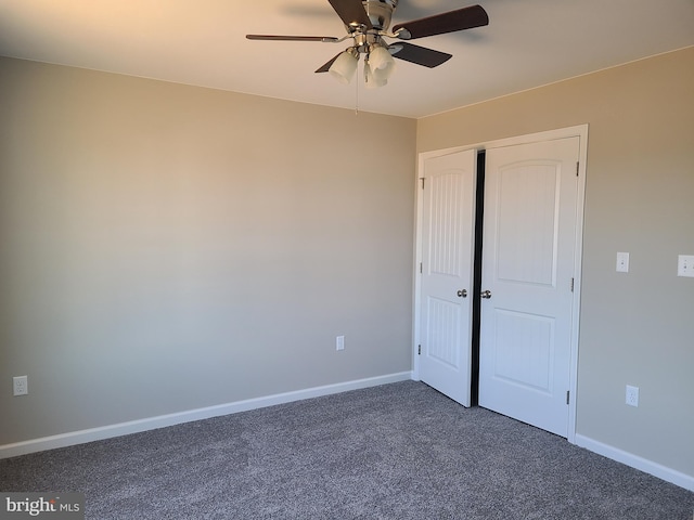 unfurnished bedroom with a ceiling fan, baseboards, dark colored carpet, and a closet