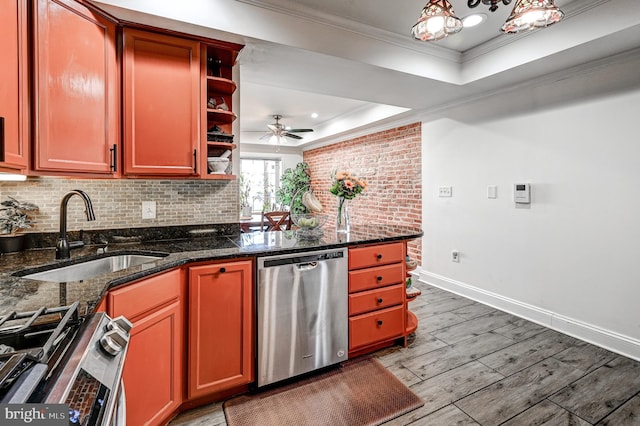 kitchen featuring sink, appliances with stainless steel finishes, dark stone counters, wood-type flooring, and crown molding