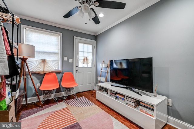 living room featuring hardwood / wood-style floors, ceiling fan, and crown molding