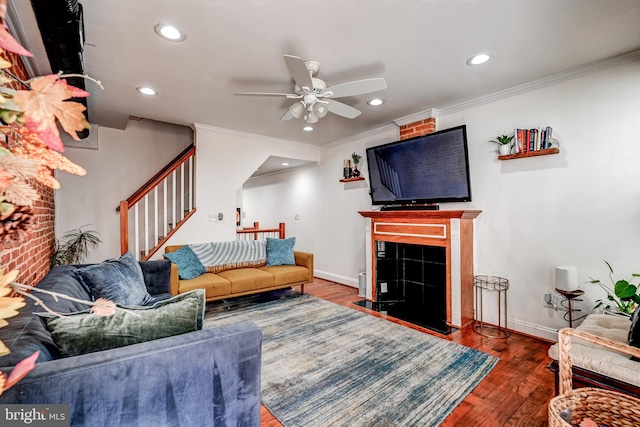 living room with hardwood / wood-style flooring, ceiling fan, and crown molding