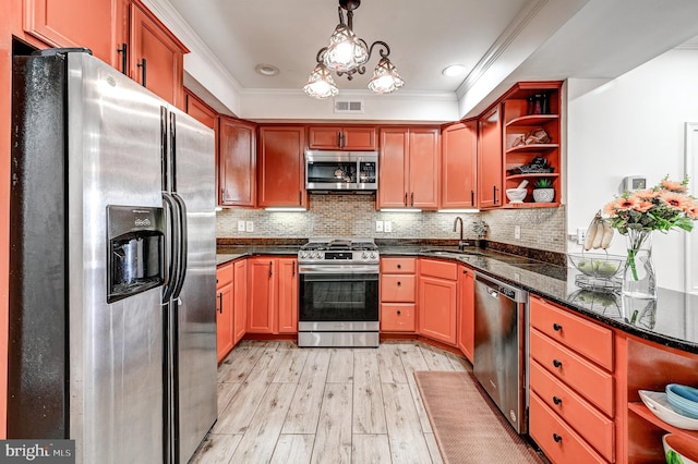 kitchen featuring crown molding, light wood-type flooring, appliances with stainless steel finishes, decorative light fixtures, and sink