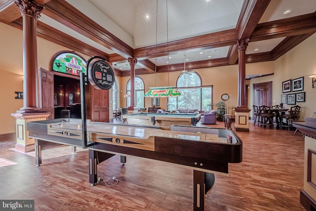 rec room featuring a high ceiling, wood-type flooring, and decorative columns