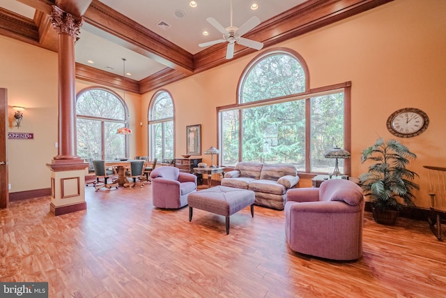 living room featuring beamed ceiling, ceiling fan, light hardwood / wood-style flooring, crown molding, and decorative columns