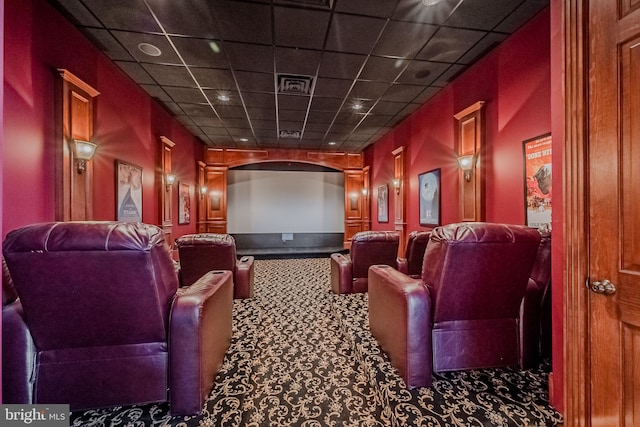 cinema with a drop ceiling and carpet flooring