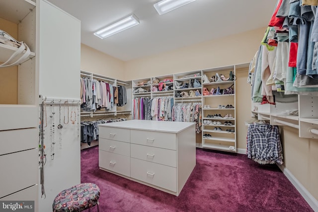 walk in closet with dark colored carpet