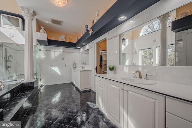 bathroom featuring ornate columns, an enclosed shower, and vanity