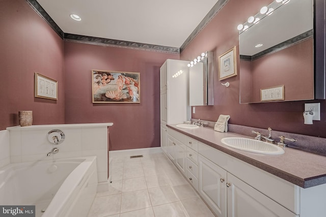 bathroom with tile patterned flooring, vanity, and a tub