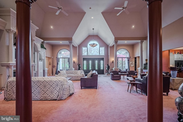 carpeted living room featuring a healthy amount of sunlight, high vaulted ceiling, and decorative columns