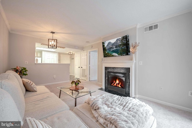 living room with crown molding, a textured ceiling, a fireplace, light colored carpet, and a chandelier