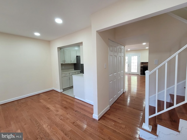 hall featuring french doors and light wood-type flooring