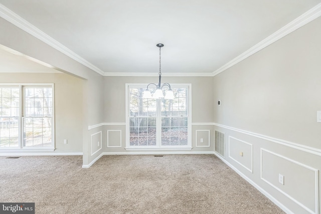 unfurnished dining area with light colored carpet, a healthy amount of sunlight, and crown molding