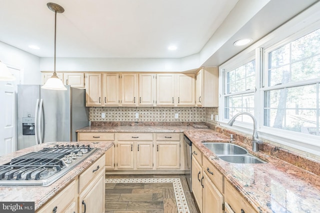 kitchen featuring backsplash, appliances with stainless steel finishes, hanging light fixtures, sink, and dark wood-type flooring