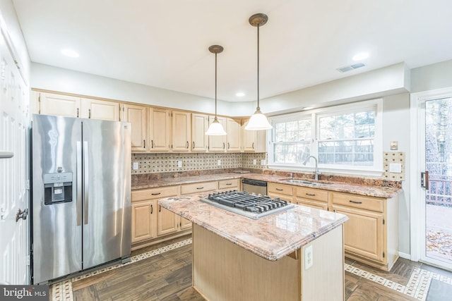 kitchen with a wealth of natural light, stainless steel appliances, sink, and a kitchen island