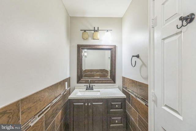 bathroom featuring vanity and tile walls