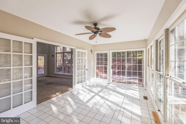 unfurnished sunroom with ceiling fan