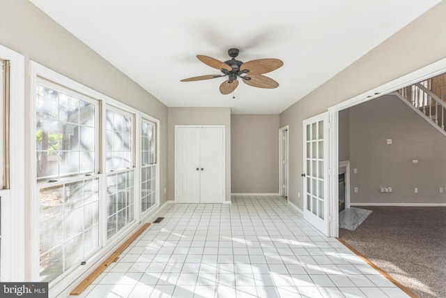 unfurnished sunroom with ceiling fan