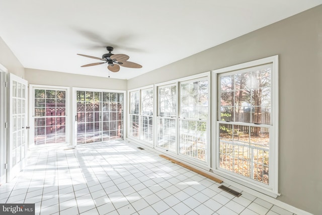 unfurnished sunroom featuring a wealth of natural light and ceiling fan