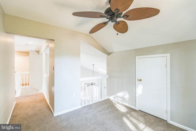 unfurnished room with ceiling fan, vaulted ceiling, and carpet