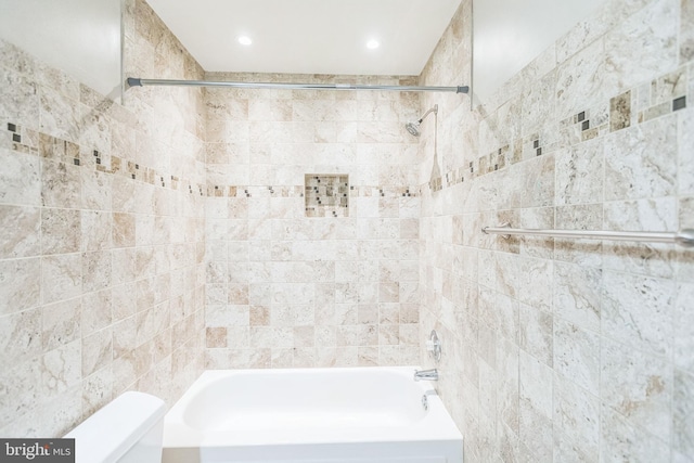 bathroom with tiled shower / bath and toilet