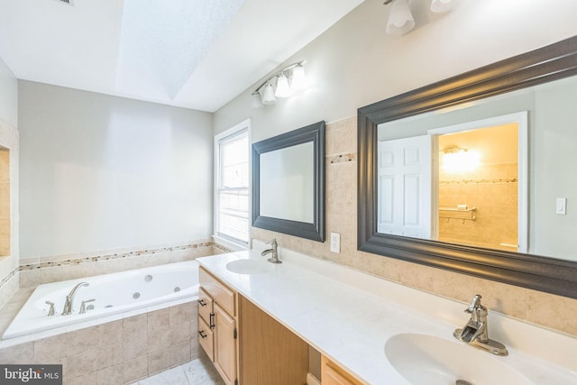 bathroom with vanity, tile patterned flooring, and tiled tub