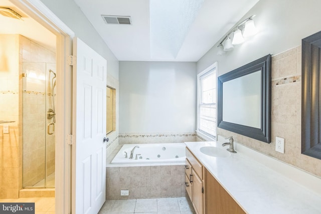 bathroom featuring tile patterned flooring, vanity, and separate shower and tub