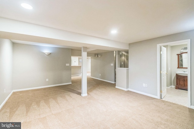 basement with sink and light colored carpet