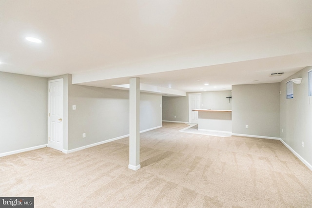 basement featuring light colored carpet