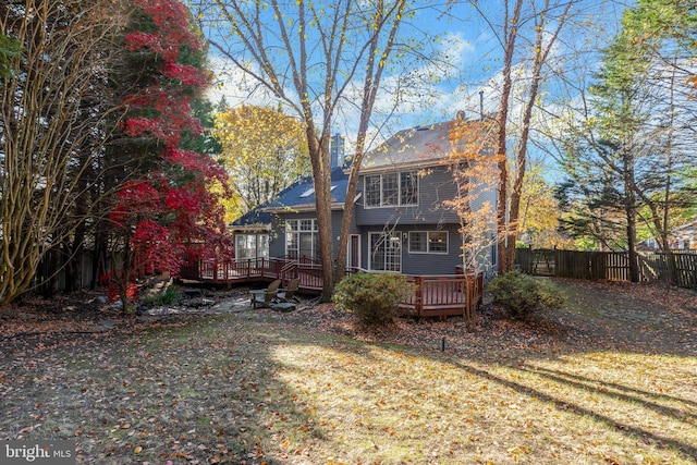 rear view of property with a deck and a lawn